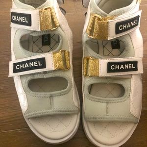 Non authentic Chanel dad foam sandals in white / gold with black logo .
